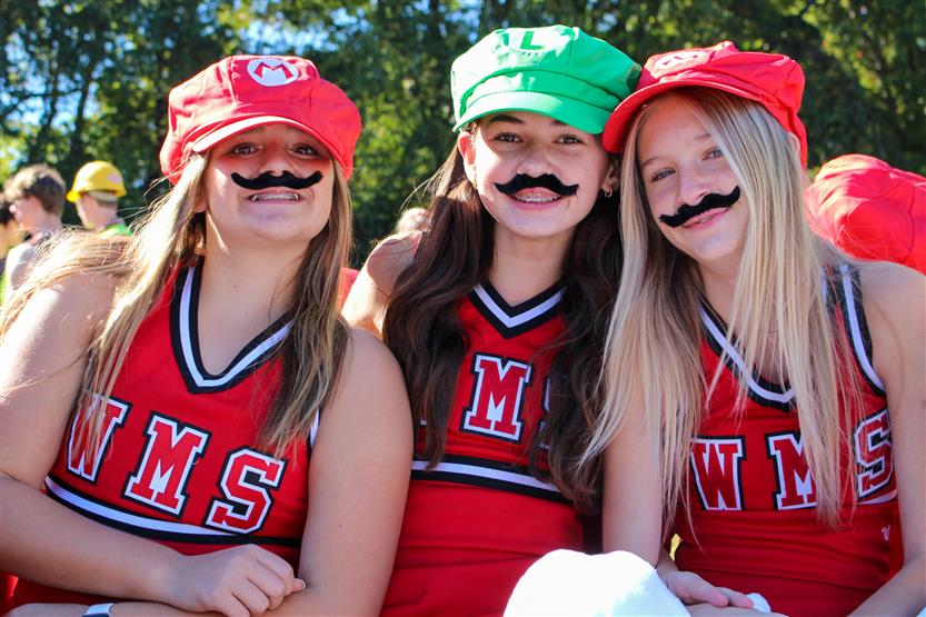 Three students wear Mario and Luigi hats